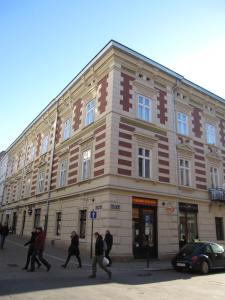un grupo de personas caminando frente a un edificio en Rembrandt Aparthotel, en Cracovia