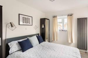 a bedroom with a bed with blue pillows and a window at Cosy Brand new spacious 1 bed luxury apartment in Birmingham