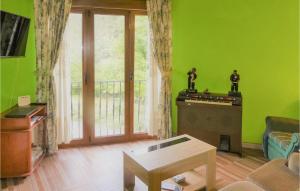 a living room with green walls and a piano at Gorgeous Home In Corredoria With Kitchenette 