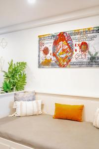 un sofá con 2 almohadas y una pintura en la pared en Spacious 1BR Suite just minutes from High Park en Toronto