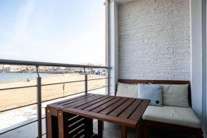 Cabanon avec terrasse - bord de plage - Le Cabanon 12 في مارسيليا: شرفة مع مقعد وإطلالة على الشاطئ