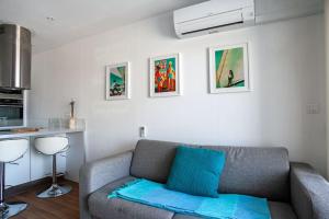 ein Wohnzimmer mit einem Sofa und einer Küche in der Unterkunft Cabanon avec terrasse - bord de plage - Le Cabanon 12 in Marseille