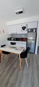 eine Küche mit Tisch und eine Küche mit Herd in der Unterkunft Monoambiente del barquito Alquiler temporario Rosario in Rosario