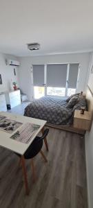a bedroom with a bed and a desk and a table at Monoambiente del barquito Alquiler temporario Rosario in Rosario