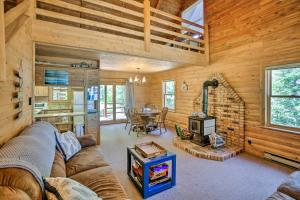 a living room with a couch and a stove at Waterfront Lake Leelanau Log Cabin with Private Dock in Lake Leelanau