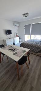 ein Wohnzimmer mit einem Tisch und einem Bett in der Unterkunft Monoambiente del barquito Alquiler temporario Rosario in Rosario
