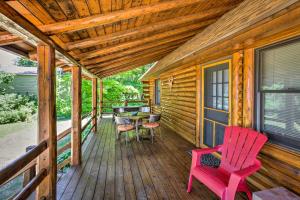 a porch of a cabin with a table and chairs at Waterfront Lake Leelanau Log Cabin with Private Dock in Lake Leelanau