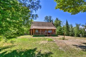 a log cabin in a field with trees at Waterfront Lake Leelanau Log Cabin with Private Dock in Lake Leelanau