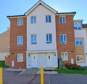 a large brick building with two white doors at 4BR Contractor Town House 2.5bathrooms, 2 free parking spaces managed by Chique Properties in Milton Keynes
