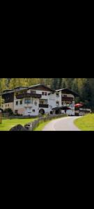 two pictures of a house with a driveway and a building at Landgasthaus Appartement Birkegg in Leutasch