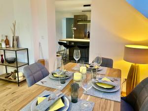 uma sala de jantar com uma mesa com copos de vinho em Appartements BERGTRAUM em Gröbming