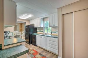 a kitchen with white cabinets and a black refrigerator at Suwannee Riverfront Home Grill, Near Springs in Branford