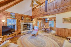 sala de estar con TV y chimenea en Lakefront Blairsville Cabin with Deck and Dock!, en Blairsville