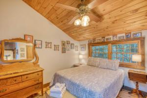 1 dormitorio con cama, espejo y tocador en Lakefront Blairsville Cabin with Deck and Dock!, en Blairsville