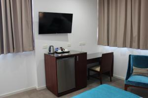 a hotel room with a television and a desk at Quality Hotel Regent Rockhampton in Rockhampton