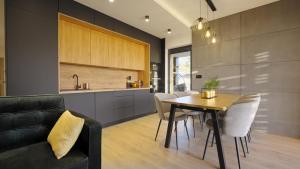 a kitchen and dining room with a table and chairs at BLACK ROCKS domki na wynajem in Nowy Sącz