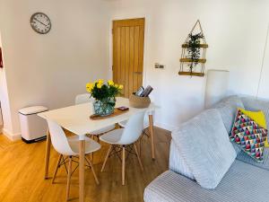 a living room with a table and a blue couch at Salt Yard Apartment, Parking and Terrace, Whitstable in Whitstable