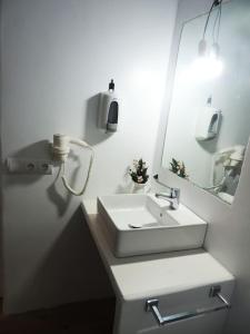 a white bathroom with a sink and a mirror at Suite La Savina Formentera con vistas al mar in La Savina