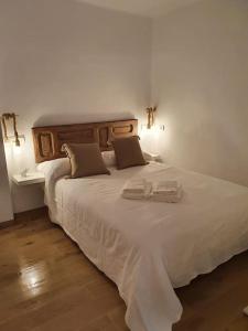 uma grande cama branca com duas toalhas em Suite La Savina Formentera con vistas al mar em La Savina