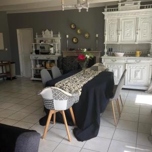 ein Esszimmer mit einem Tisch und Stühlen in einer Küche in der Unterkunft la cressonniere in Aulnay