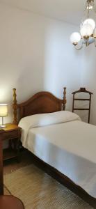 ein Schlafzimmer mit einem Bett und einem Tisch mit einer Lampe in der Unterkunft Vivenda Miraflores in Armação de Pêra
