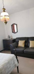 ein Wohnzimmer mit einem schwarzen Sofa und einem Spiegel in der Unterkunft Vivenda Miraflores in Armação de Pêra