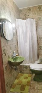 ein Badezimmer mit einem grünen Waschbecken und einem WC in der Unterkunft Vivenda Miraflores in Armação de Pêra