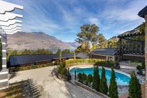 an aerial view of a house with a swimming pool and mountains at Alpine Cottage in Queenstown