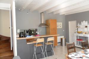 eine Küche mit einer Theke und Stühlen in der Unterkunft la cressonniere in Aulnay