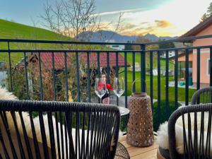 uma varanda com uma mesa e um copo de vinho em Appartements BERGTRAUM em Gröbming