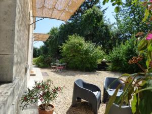 eine Terrasse mit Stühlen und Tischen im Garten in der Unterkunft la cressonniere in Aulnay