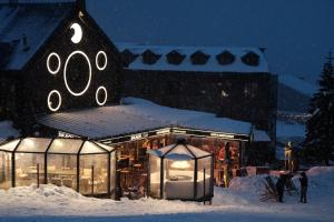 a building with lights in the snow at night at Oksijen Zone Hotel & Spa in Uludag