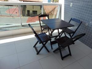 una mesa negra y sillas sentadas en un balcón en Ed. Le Bon Vivant, en Arraial do Cabo