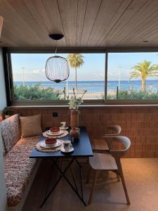 - un salon avec une table et une vue sur l'océan dans l'établissement LUXURIOUS APARTMENT ON THE BEACH, à Saint-Laurent-du-Var