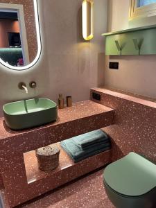 La salle de bains est pourvue d'un lavabo vert et de toilettes. dans l'établissement LUXURIOUS APARTMENT ON THE BEACH, à Saint-Laurent-du-Var