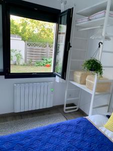 sypialnia z oknem i łóżkiem z niebieską pościelą w obiekcie Studio Cocooning à 15 mn de Paris et à 8 mn du RER A ! w mieście Sartrouville