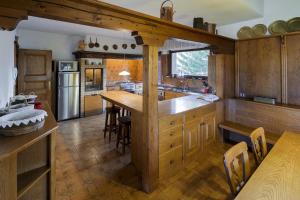 une grande cuisine avec des placards en bois et un comptoir. dans l'établissement Villa Pocol - Stayincortina, à Cortina dʼAmpezzo