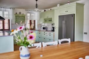 a kitchen with a table and a refrigerator at Vila Starý mlýn in Proseč