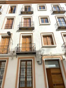 un edificio bianco con finestre e balconi di Hispalis Plaza de Santa Cruz a Siviglia