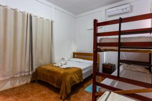 a bedroom with two bunk beds and a bed with a table at Pousada Chão de pedra in Bonito