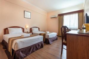 a hotel room with two beds and a desk at Hotel Seri Malaysia Ipoh in Ipoh +15 photos