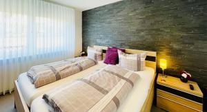 2 Betten in einem Schlafzimmer mit Ziegelwand in der Unterkunft Ferienwohnung Zeitlos in Attendorn