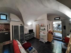 un soggiorno con divano e scrivania in una camera di ROSEROSSE casa vacanze a Sanremo