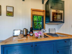 een keuken met blauwe kasten en een aanrecht bij The Dalesbred Hut - Uk40150 in Rathmell