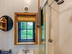 een badkamer met een raam, een wastafel en een douche bij The Dalesbred Hut - Uk40150 in Rathmell