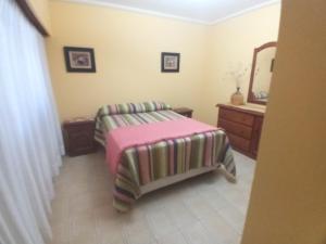 Un dormitorio con una cama con una manta rosa. en Casa Marques, en Santa Rosa 4 fotos más