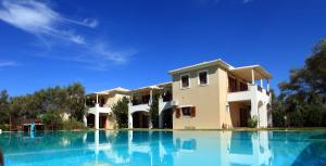 a large swimming pool in front of a house at Olivastro Villa in Lefkada Town