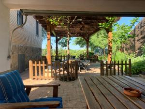 een houten terras met een tafel en stoelen erop bij JARAMUNDI in Villa del Prado