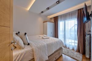 a bedroom with a bed and a large window at Apartman M61 Lux&Spa,vila Elsa 2 in Zlatibor