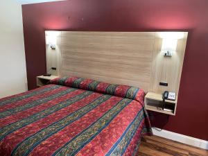 Habitación de hotel con cama y pared roja en Jameson Inn Conyers, en Conyers